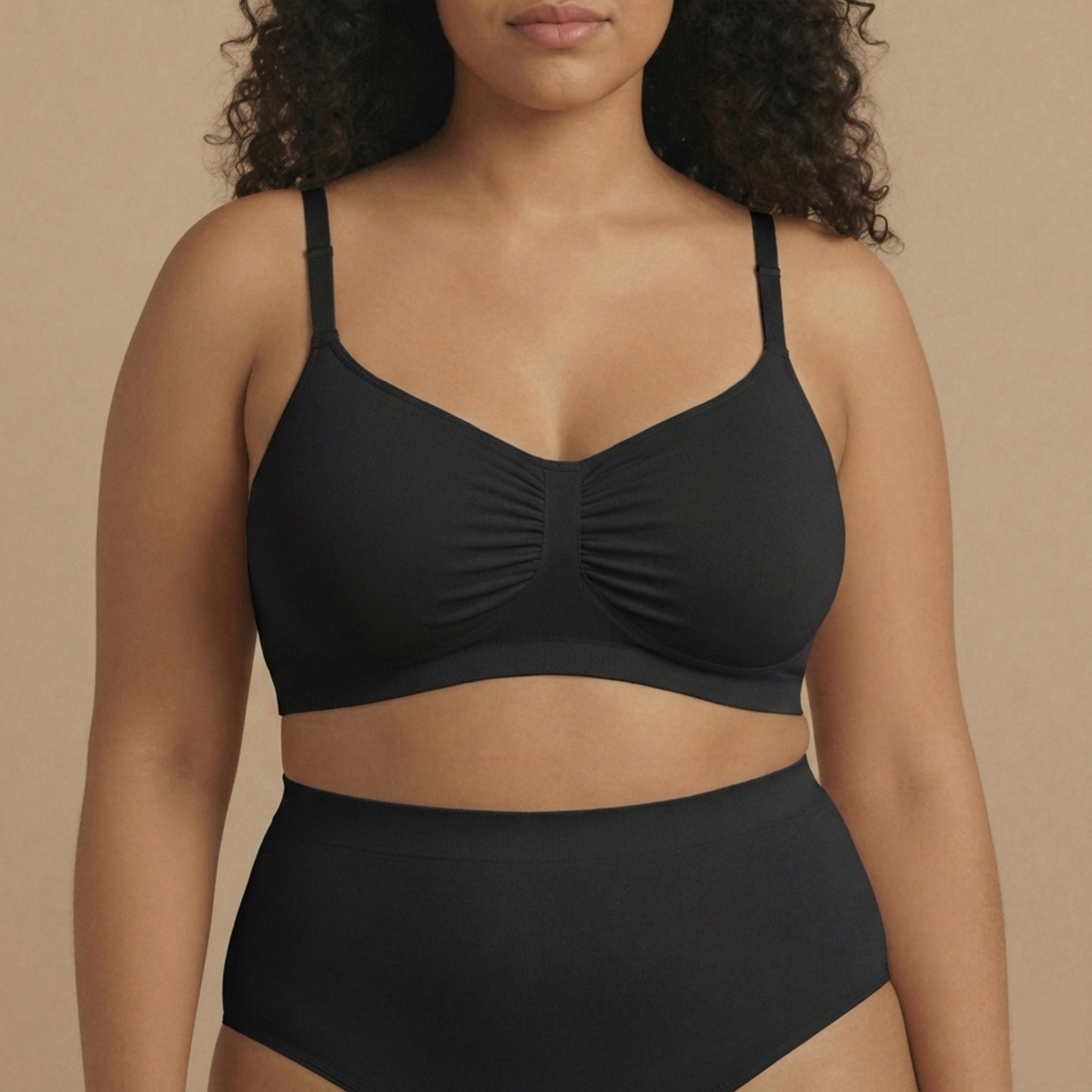 Woman wearing a black bikini set against a beige background