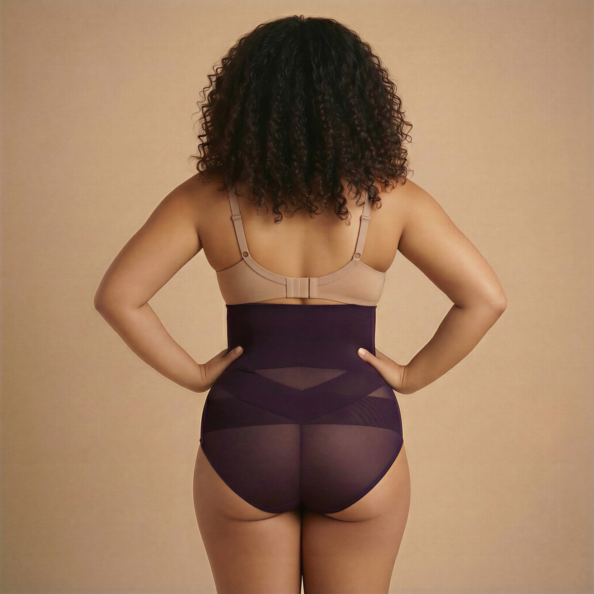 Person wearing a beige bra and purple shapewear on a beige background