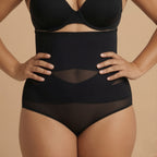 Person wearing a black shapewear garment on a beige background