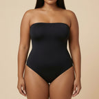 Black strapless swimsuit worn by a model on a beige background