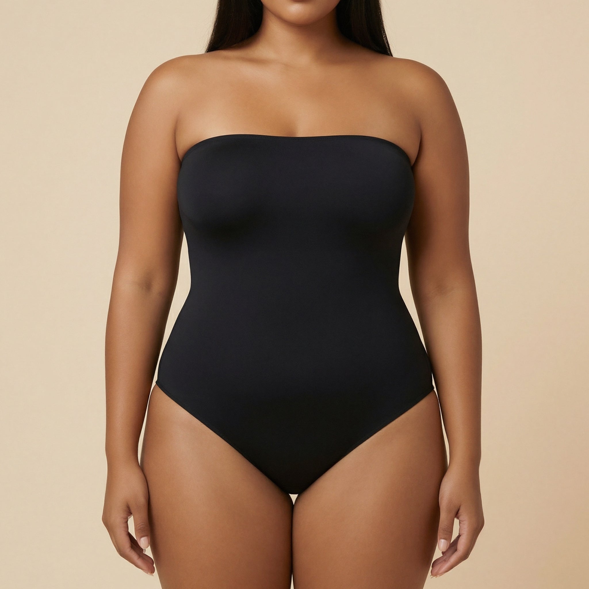 Black strapless swimsuit worn by a model on a beige background